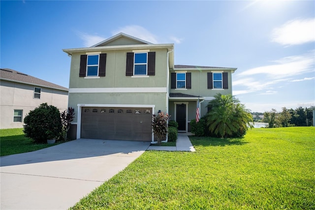 view of front facade featuring an attached garage, driveway, a front lawn, and stucco siding