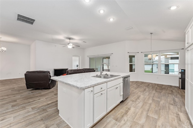 kitchen featuring white cabinets, an island with sink, sink, and hanging light fixtures