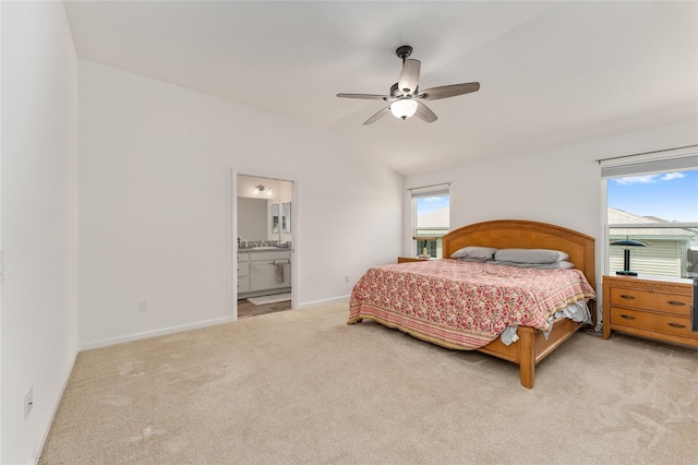 carpeted bedroom featuring multiple windows, lofted ceiling, connected bathroom, and ceiling fan