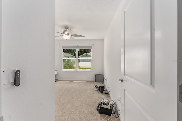 interior space with light carpet and ceiling fan