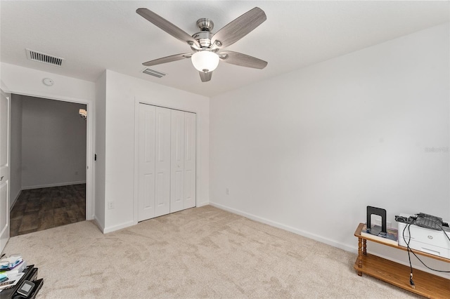 carpeted bedroom featuring ceiling fan and a closet