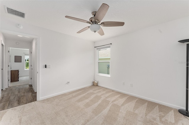 unfurnished bedroom featuring multiple windows, ceiling fan, and light colored carpet