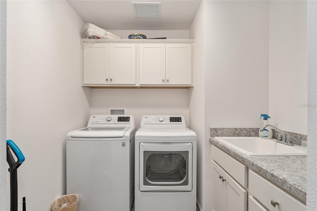 washroom featuring cabinets, sink, and washing machine and clothes dryer