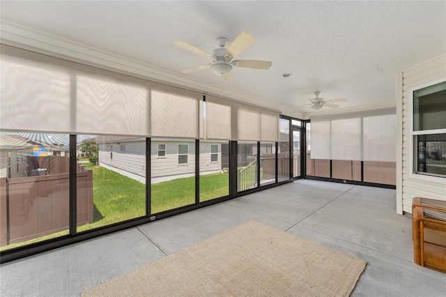 unfurnished sunroom with ceiling fan