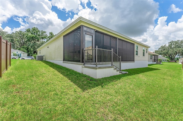 rear view of property featuring a yard and central AC unit