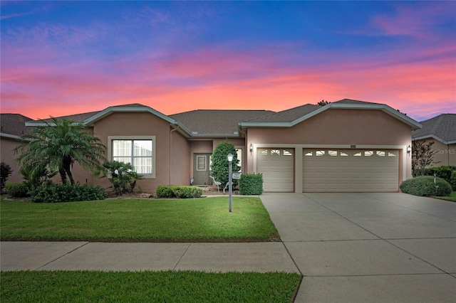 single story home featuring a lawn and a garage