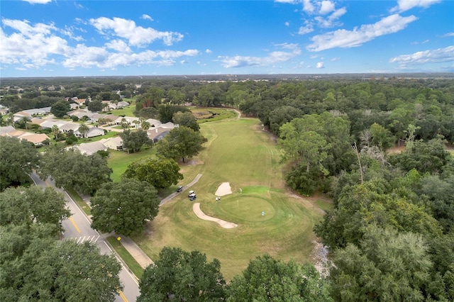 aerial view with view of golf course and a forest view