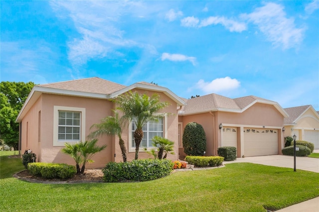 ranch-style house featuring an attached garage, a shingled roof, concrete driveway, stucco siding, and a front yard