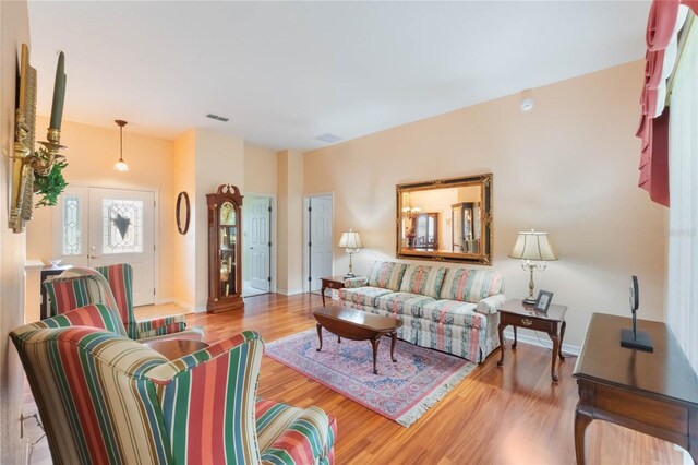 living area featuring baseboards, visible vents, and wood finished floors