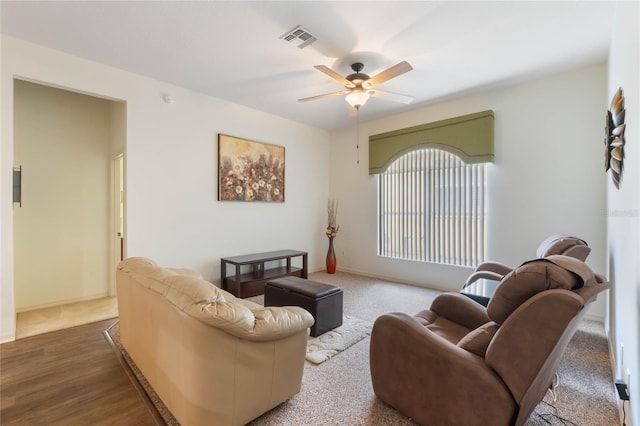 living room featuring ceiling fan, visible vents, and baseboards