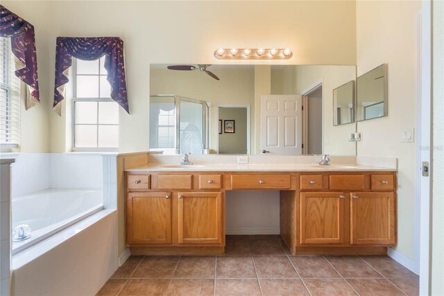 bathroom with a garden tub, tile patterned flooring, and a sink