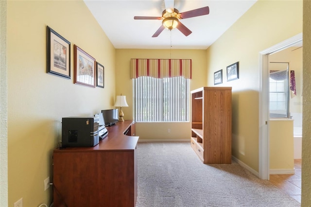 carpeted office featuring a wealth of natural light, ceiling fan, and baseboards