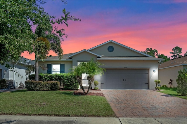 ranch-style house featuring a yard and a garage