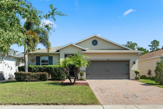 ranch-style home with an attached garage, a front yard, decorative driveway, and stucco siding