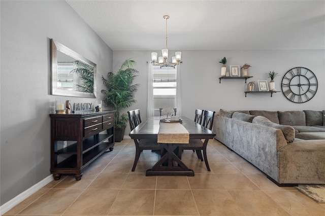 tiled dining room featuring a chandelier