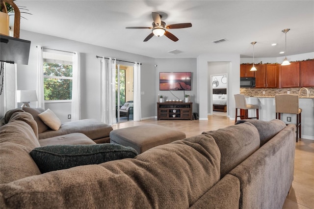 tiled living room with sink and ceiling fan