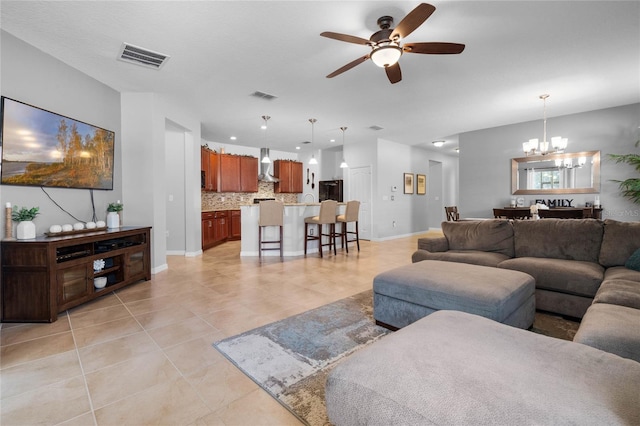 tiled living room featuring ceiling fan with notable chandelier