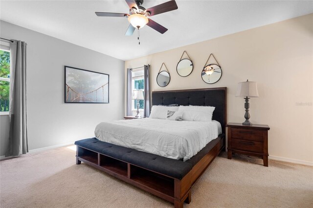 carpeted bedroom featuring ceiling fan and multiple windows