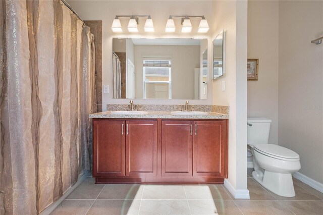 bathroom featuring double vanity, toilet, and tile patterned flooring