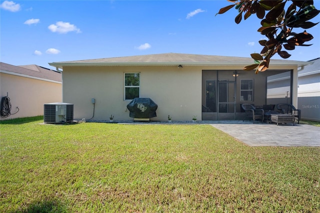 rear view of house with central air condition unit, a lawn, and a patio