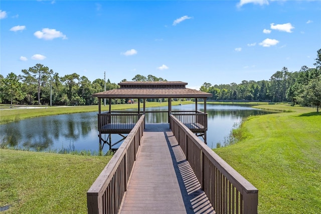 dock area with a lawn, a water view, and a gazebo