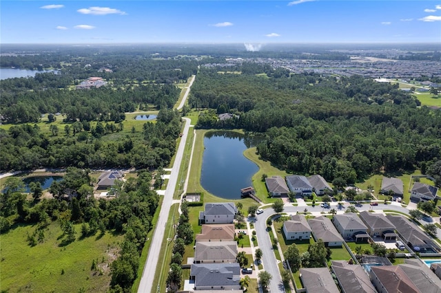 drone / aerial view with a water view, a wooded view, and a residential view