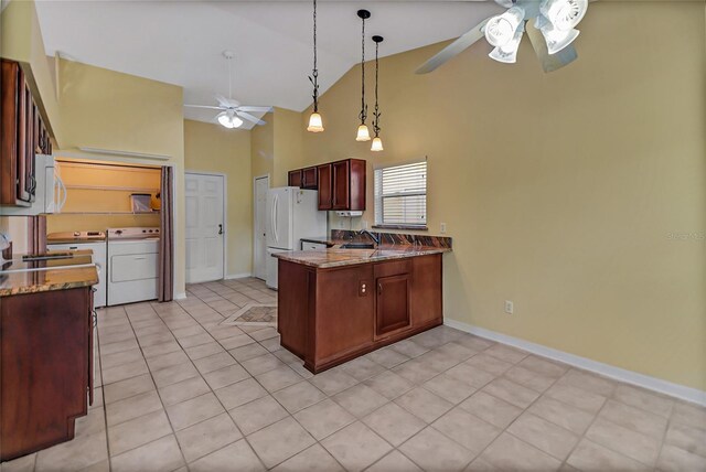 kitchen with decorative light fixtures, washer / dryer, ceiling fan, light tile patterned flooring, and dark stone countertops