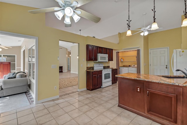 kitchen with white appliances, a ceiling fan, washing machine and clothes dryer, pendant lighting, and a sink