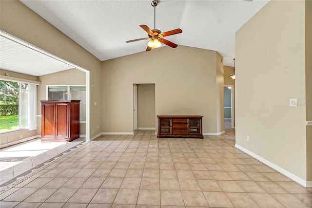 unfurnished living room with a textured ceiling, light tile patterned flooring, a ceiling fan, baseboards, and vaulted ceiling