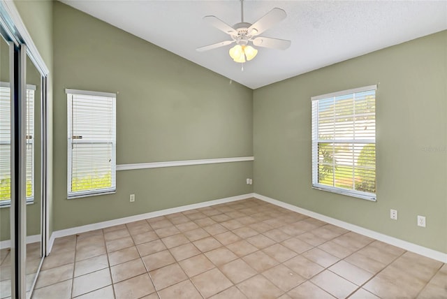 tiled spare room featuring ceiling fan