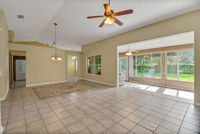 spare room with lofted ceiling, light tile patterned flooring, visible vents, and ceiling fan with notable chandelier