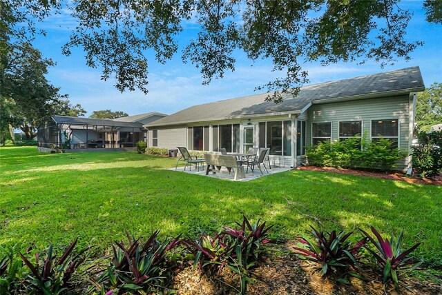 rear view of property with a lanai, a patio area, and a yard