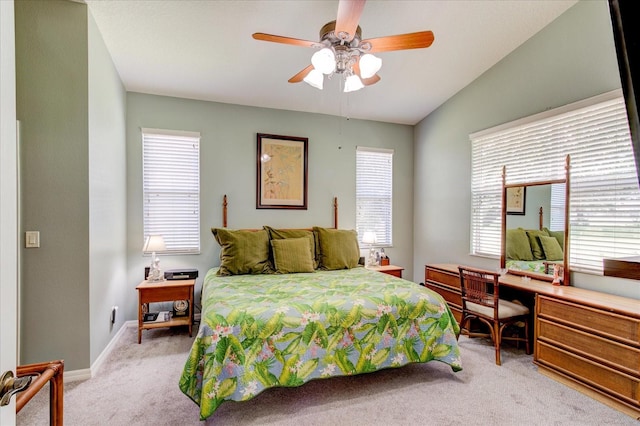 carpeted bedroom with ceiling fan, multiple windows, and lofted ceiling