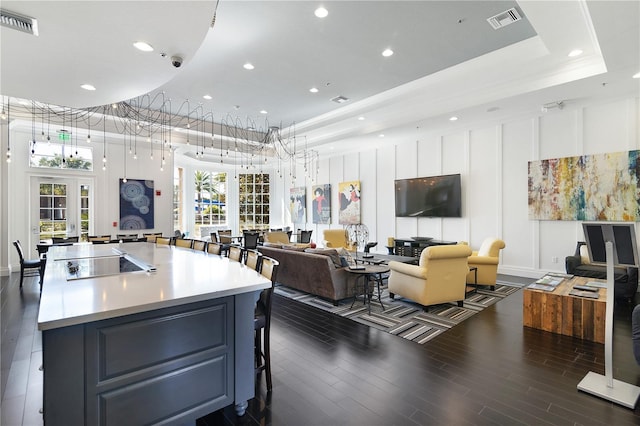 kitchen featuring a center island, black electric cooktop, dark wood-type flooring, french doors, and a raised ceiling