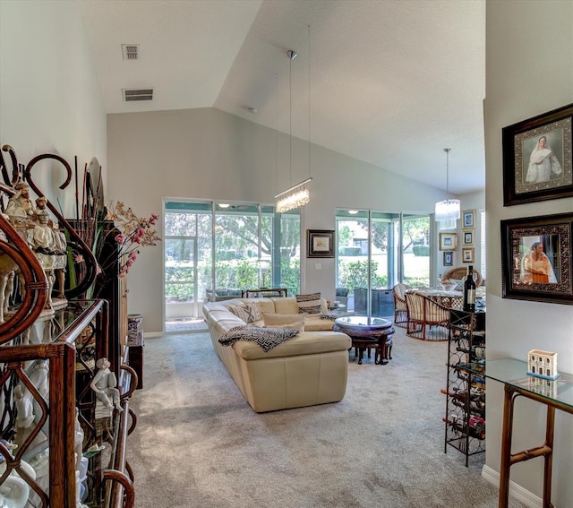 carpeted living room with high vaulted ceiling and a chandelier