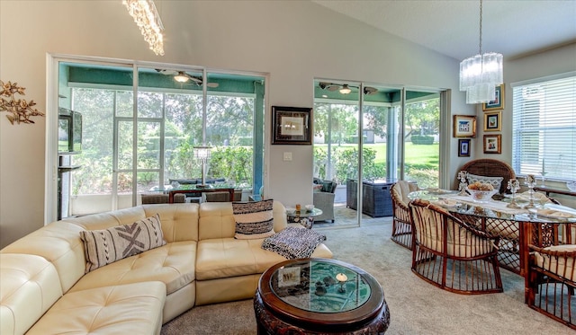 carpeted living room featuring a notable chandelier and lofted ceiling