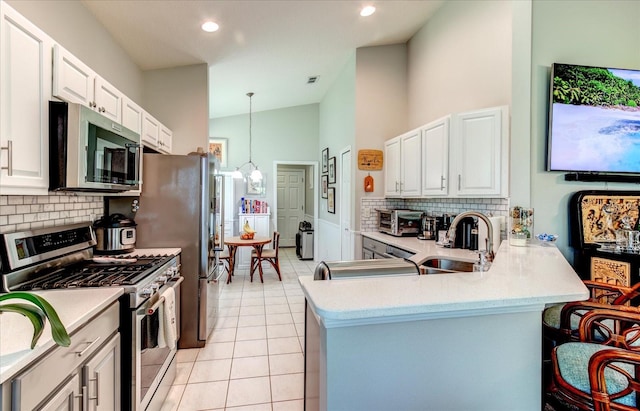 kitchen with appliances with stainless steel finishes, light tile patterned flooring, sink, and backsplash