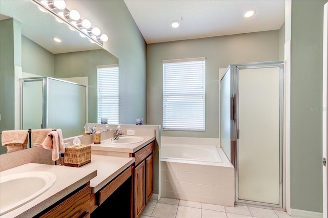 bathroom with a wealth of natural light, shower with separate bathtub, vanity, and tile patterned floors