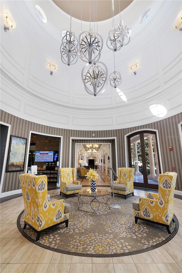 interior space featuring a high ceiling, french doors, and a chandelier