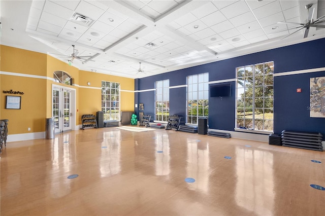 workout area with a towering ceiling, ceiling fan, french doors, and coffered ceiling