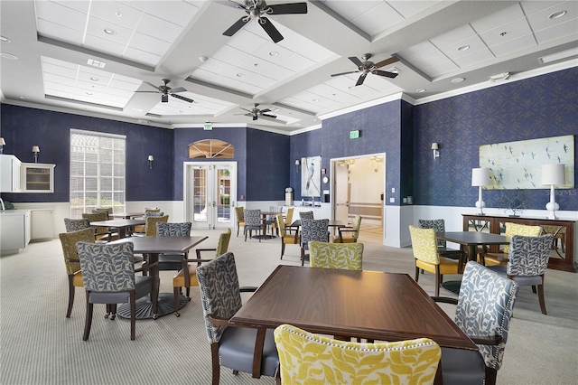 dining space featuring ceiling fan, light colored carpet, coffered ceiling, ornamental molding, and french doors