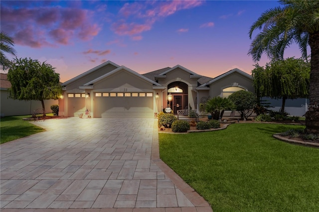 view of front of home featuring a garage and a yard