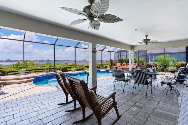 view of patio featuring glass enclosure, a pool with hot tub, and ceiling fan