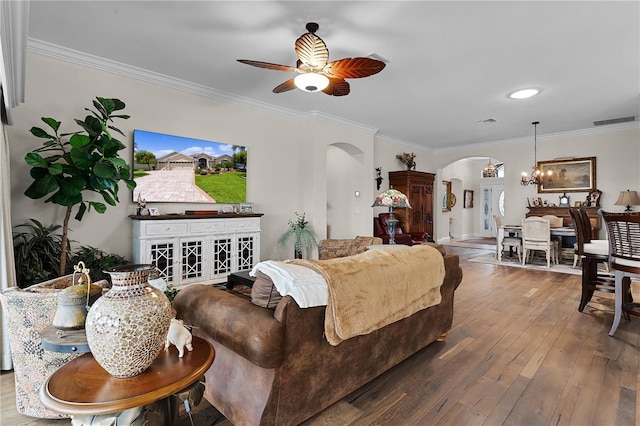 living room with ceiling fan with notable chandelier, hardwood / wood-style floors, and ornamental molding