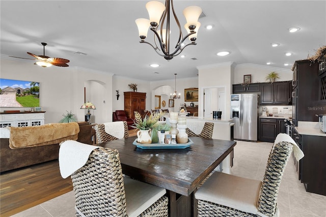 tiled dining space with ceiling fan with notable chandelier, lofted ceiling, and ornamental molding