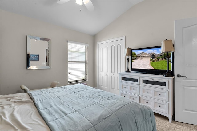 carpeted bedroom with ceiling fan, a closet, and lofted ceiling