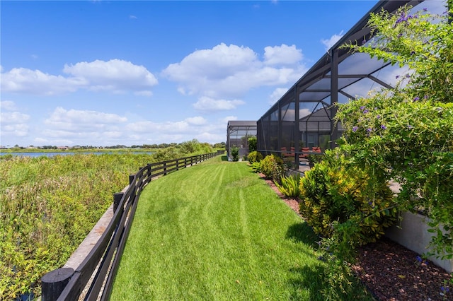 view of yard featuring a lanai and a water view