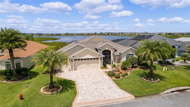 single story home featuring a garage, a front yard, and a water view