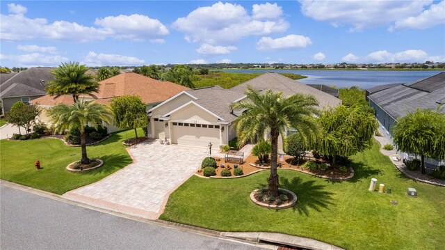 view of front of home featuring a garage, a front lawn, and a water view