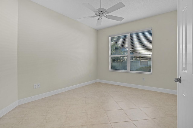 tiled empty room featuring ceiling fan and a textured ceiling